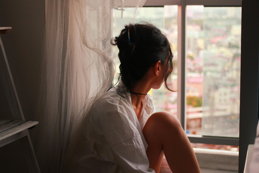 Una ragazza che guarda fuori dalla finestra in un momento di dolce far niente